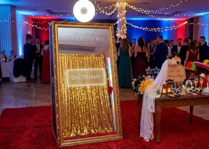 Eleganckie fotolustro w złotej ramie z czerwonym dywanem na sali weselnej w Łodzi.